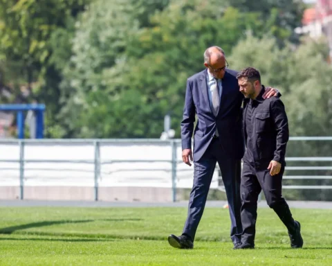 a man in suit walking with another man in suit