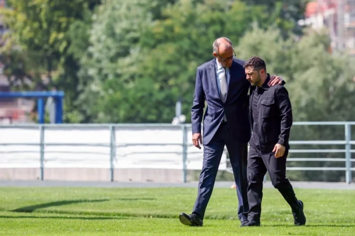 a man in suit walking with another man in suit